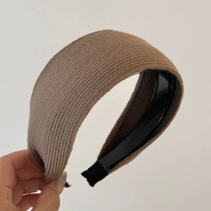 Detail of brown knitted wide headband showing ribbed texture and non-slip inner teeth