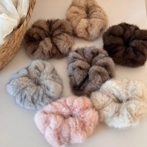 Set of 7 colorful plush scrunchies in neutral tones on minimalist lifestyle background