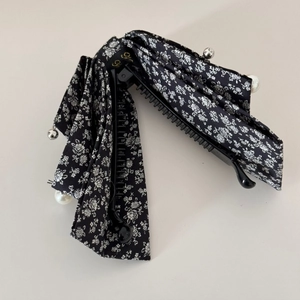 Detail of floral fabric bow banana clip featuring large pearls and silver accent beads