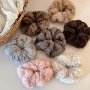 Detailed close-up of fluffy faux fur oversized scrunchies in various earth tone colors