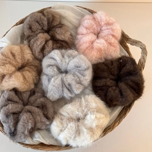 Detailed set of seven plush faux fur scrunchies in soft neutral and pastel tones