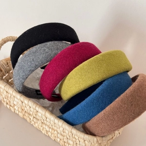 Detailed view of assorted thick wool felt headbands in multiple vibrant colors inside a basket
