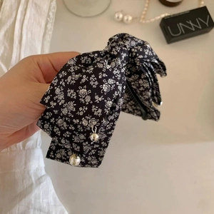 Detail of floral fabric banana clip with elegant pearls and charms for hair styling