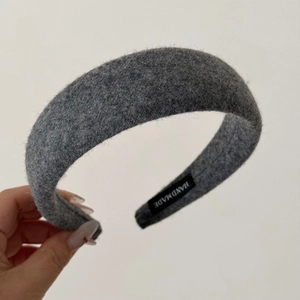 Macro shot of grey wool headband texture and inner handmade fabric label detail