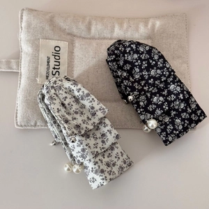 Detailed view of floral fabric banana hair clips with elegant pearl and bead trim