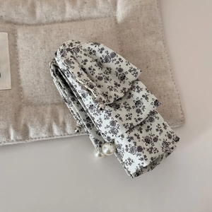 Detailed macro view of multi-layered floral fabric hair clip with white faux pearls