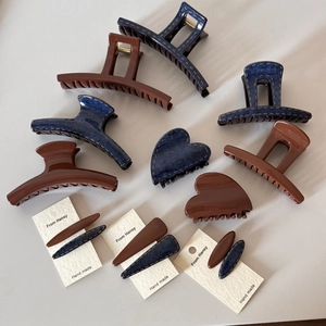 Detail of coffee brown and denim blue hair clips featuring crescent and heart shapes