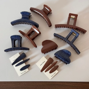 Detail of dark brown and blue denim texture hair clips with yellow stitching accents