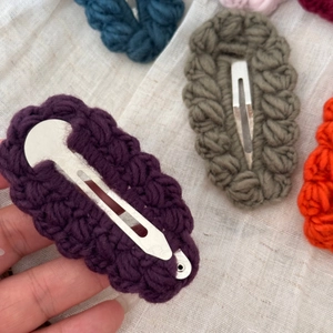Dettaglio di fermagli per capelli in lana fatti a mano all'uncinetto in colori autunnali
