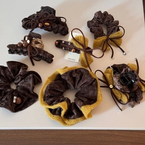 Detailed close-up of velvet bow hair clips and scrunchies in warm autumn colors