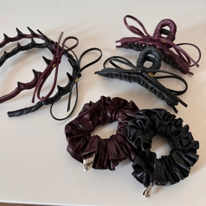Close-up of elegant PU leather hair accessories including bow clips and shark clips