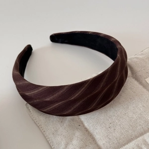 Close-up detail of dark brown twill fabric headband with soft elegant texture