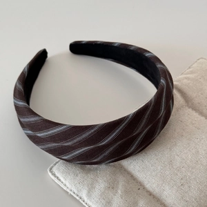 Close-up of brown twill headband with fine diagonal stripes and premium fabric texture