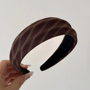 Detailed close-up of brown twill wide headband with premium pleated texture and non-slip lining