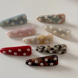 Détail d'un lot de huit barrettes colorées en acétate avec petites fleurs décoratives