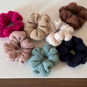 Dettaglio di sette elastici per capelli in maglia con trama spessa in diversi colori