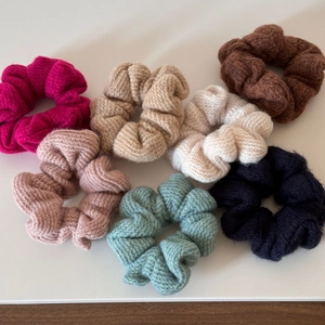 Vista dettagliata di sette elastici per capelli in maglia colorata con trama a coste