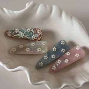 Détails des barrettes en acétate à fleurs, finitions marbre coloré et tons pastel