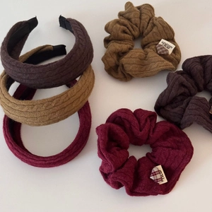 Détail d'accessoires à cheveux en tricot torsadé marron, kaki et bordeaux avec patch cœur