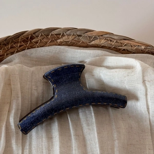 Macro shot of large denim blue hair claw clip with contrast yellow stitching details
