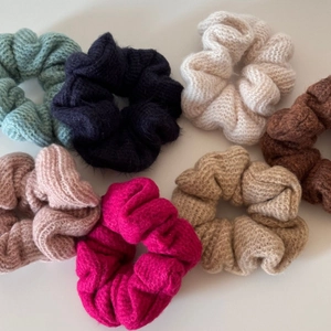 Dettaglio di sette elastici per capelli in maglia colorata in morbido tessuto autunnale