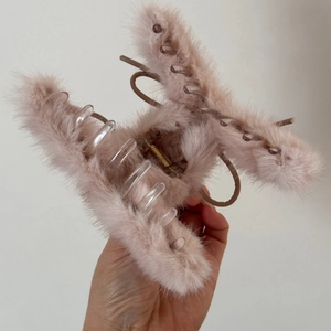 Détail d'une pince à cheveux en fausse fourrure rose clair avec mécanisme à ressort solide