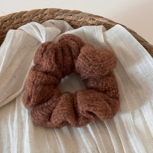 Dettaglio dell'elastico in peluche marrone scuro che mostra la consistenza morbida