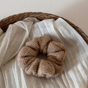 Dettaglio di un elastico in maglia color cammello con trama fine in stile autunnale