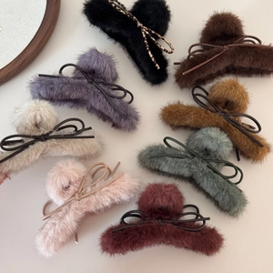 Détail de pinces à cheveux en fausse fourrure avec nœuds en cuir en plusieurs tons