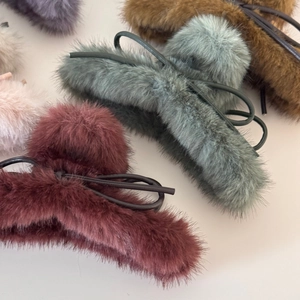 Vue détaillée de pinces à cheveux en fausse fourrure avec nœuds en cuir en plusieurs couleurs