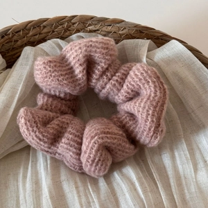 Dettaglio di un elastico per capelli rosa antico in maglia con texture mohair