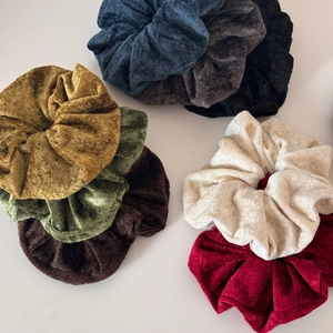 Detail of multi-color velvet scrunchies set showing soft texture and pleated design