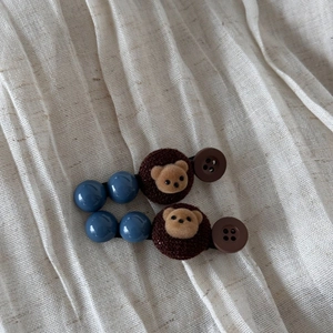 Détail de pinces à cheveux ours mignon avec perles bleues et peluche sur lin blanc élégant