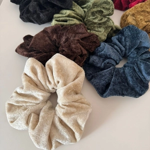 Macro view of velvet hair scrunchies in various colors with thick pleated textures