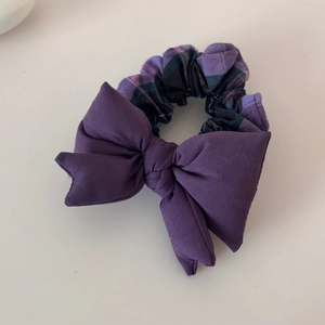 Close-up of padded purple plaid bow scrunchie with detailed stitching and soft cotton fabric