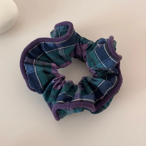 Detailed view of blue and purple plaid scrunchie with soft fabric texture and stitching