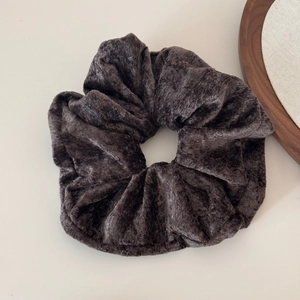 Close-up detail of oversized velvet scrunchie showing soft texture in dark coffee brown