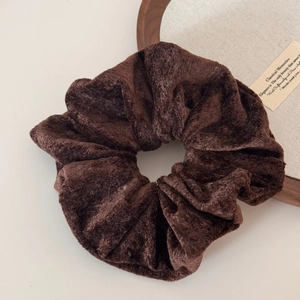 Close-up of a large dark brown velvet scrunchie featuring soft plush texture and rich sheen