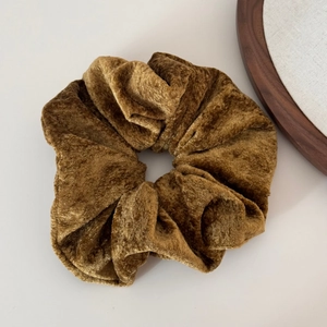 Close-up of oversized mustard gold velvet scrunchie showing plush texture and soft folds