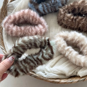 Close-up of soft plush faux fur scrunchies in various colors for autumn and winter