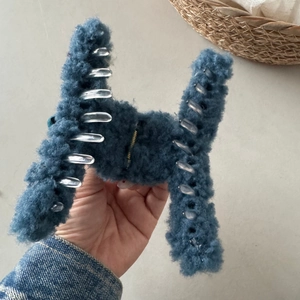 Detail of greyish-blue plush shark clip showing soft faux fur texture and sturdy teeth