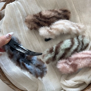 Detail view of plush faux fur hair clips in various colors with sturdy black duckbill base