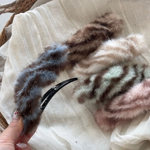 Close-up of fluffy faux fur hair clips in various colors for autumn and winter styling