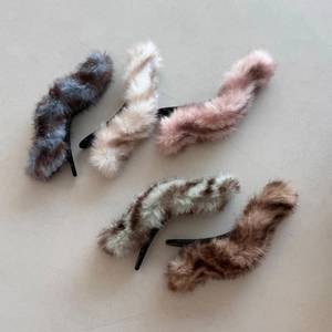 Macro view of plush velvet texture and soft faux mink fur on various wave-shaped hair clips