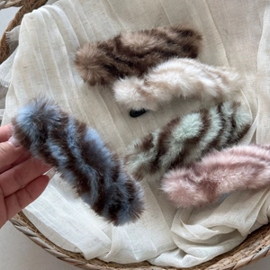 Close-up of plush striped duckbill hair clips in various colors for autumn and winter