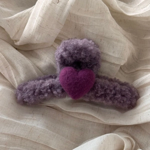 Close-up of lilac plush hair claw clip featuring a purple felt heart on textured fabric