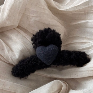 Close-up of black fuzzy wool claw clip featuring a heart accent and soft plush texture
