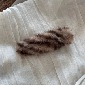 Detail view of large plush hair clip with soft brown faux mink fur and fluffy texture