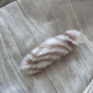 Detail shot of the plush striped hair clip with soft brown and beige faux fur texture