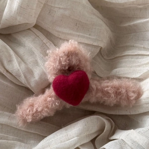Close-up of plush pink heart hair claw clip with soft faux fur texture for women